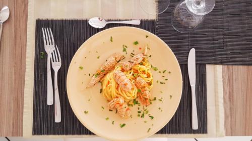 a plate of shrimp pasta on a table at Hotel Senyor in Rimini