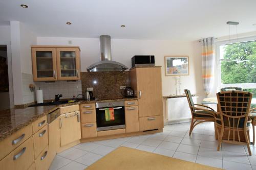a kitchen with wooden cabinets and a table and chairs at Cafe Steffens in Hahnenklee-Bockswiese