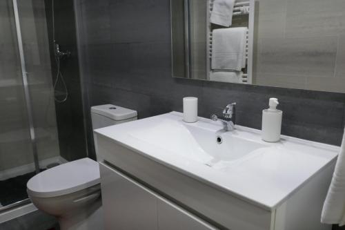 a bathroom with a white sink and a toilet at Belo Apartment in Leiria