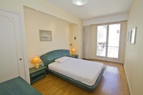 une chambre avec un lit et une grande fenêtre dans l'établissement PROMENADE HOLIDAY - SEA FRONT PALATIN, à Nice