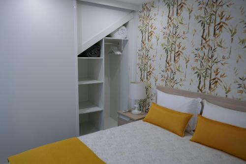 a bedroom with a bed with two yellow pillows at Belo Apartment in Leiria