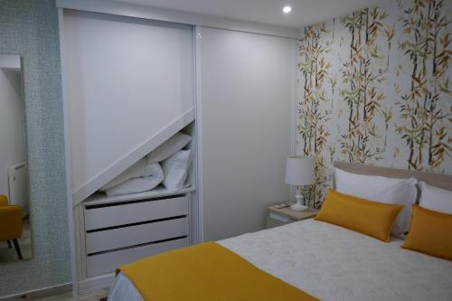 een slaapkamer met een bed met gele kussens bij Belo Apartment in Leiria