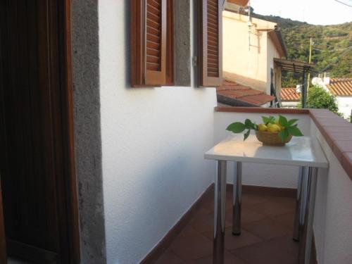 a table with a bowl of fruit on a balcony at Appartamento Il Mandarino in Pomonte