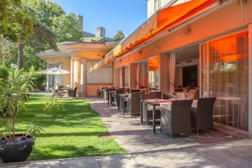 a restaurant with tables and chairs on a patio at Hotel Unione in Bellinzona