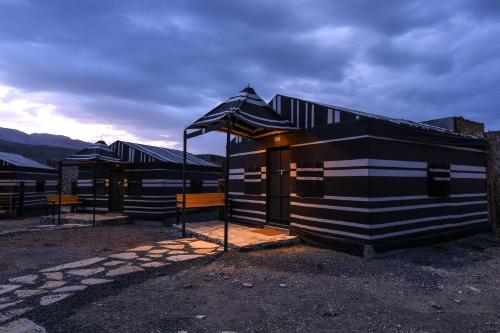 a black and white building with an umbrella at Sama Heights Resort in Dār Sawdāʼ
