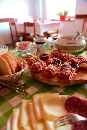 a table topped with a plate of pastries and bread at Agriturismo Pian dei Tass in Barcis