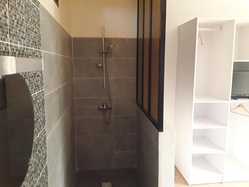 a bathroom with a shower with a glass door at Chambre d'hôte les vacanciers in Nianing