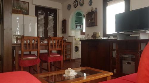 a living room with a dining table and a television at La Casa Blanca in Grottammare