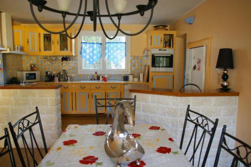 - une cuisine avec une table et un poulet dans l'établissement Coeur de Lavande, à Bédarrides