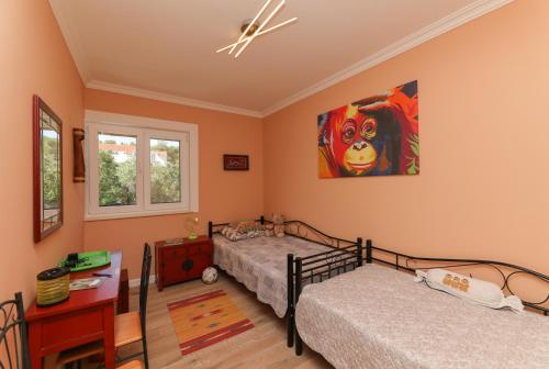 a bedroom with two beds and a painting on the wall at Ocean's Serenity in Supetar
