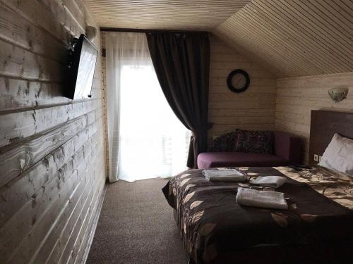 a small room with a bed and a window at Котедж in Vorokhta