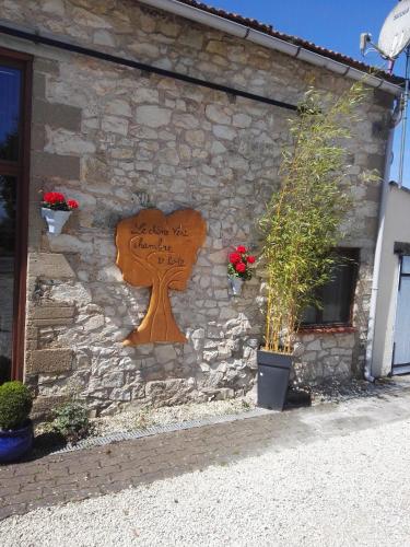 a wooden sign on the side of a building at Le Chene Vert in Millac