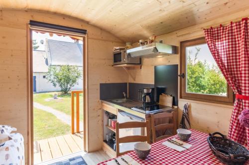 - une cuisine dans une petite maison avec une table dans l'établissement LE CLOS BRAYON, à Saint-Honoré