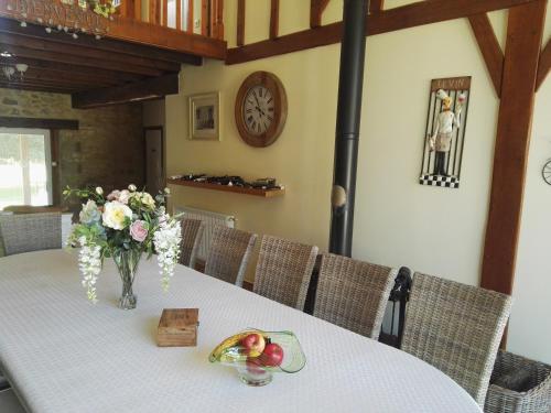 a table with a vase of flowers on it at Le Chene Vert in Millac