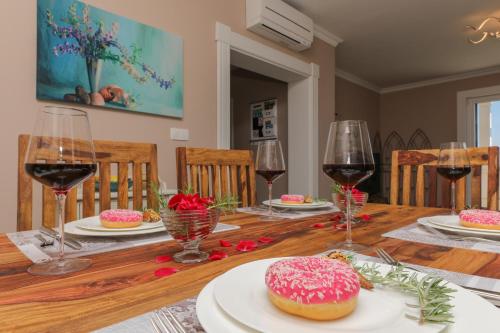 a dining room table with a pink doughnut and wine glasses at Ocean's Serenity in Supetar