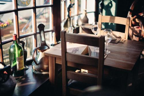 a wooden table with glasses and a bottle of wine at The Brown Horse Inn in Winster