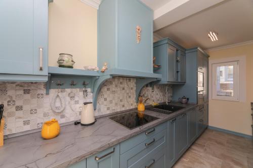 a kitchen with blue cabinets and a sink at Ocean's Serenity in Supetar