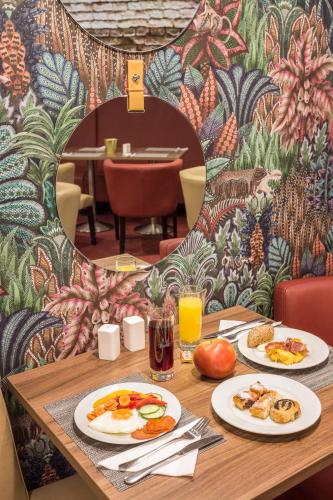 a table with two plates of breakfast food on it at Hotel Memories Budapest in Budapest