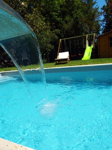 a water fountain in a swimming pool at La Maison du Moulin de Tartay in Avignon