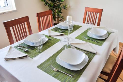 a dining room table with white plates and napkins at Casa da Villa-Grândola in Grândola