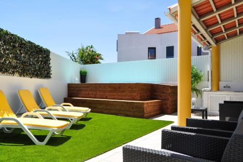 a patio with lawn chairs and a fence at Casa da Villa-Grândola in Grândola