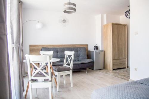 un soggiorno con divano, tavolo e sedie di Silver Apartments a Sarbinowo
