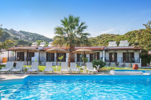um resort com piscina e cadeiras e uma casa em STRAWBERRY Skiathos em Agia Paraskevi
