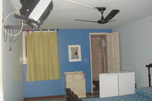 una camera da letto con pareti blu e ventilatore a soffitto di Pousada Gran Gaviota a Cabo Frio