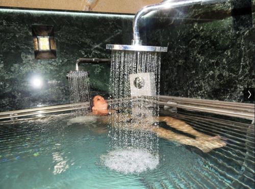 a person in a swimming pool with a water fountain at Yannis Hotel in Krinídhes