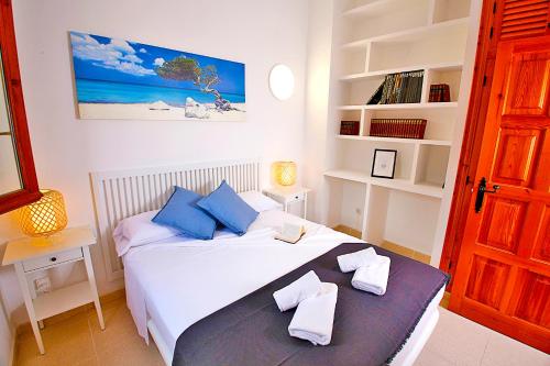 a bedroom with a bed with blue pillows at Lighthouse View II in Santa Pola