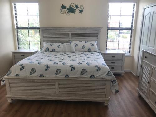 a bedroom with a large bed and two windows at Serenata Condominiums,Sarasota in Sarasota