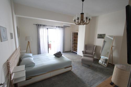 ein Schlafzimmer mit einem Bett, einem Stuhl und einem Fenster in der Unterkunft Katerina's in Néa Palátia