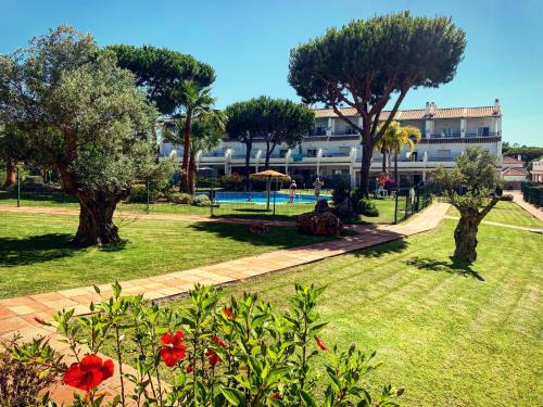 a park with trees and a building in the background at Fantastic 3-Bedroom Holiday Home including Tennis and Pool Near Golf Course in El Portil