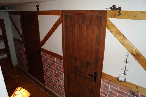 a wooden door in a room with a brick wall at Eriks Bädd och Pentry in Hillerstorp