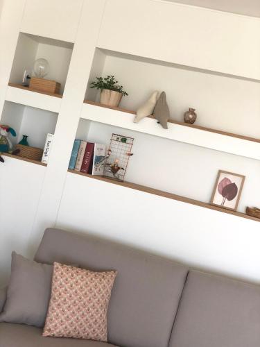 a shelf above a couch in a living room at JACARANDA II Appartement in Mandelieu-la-Napoule