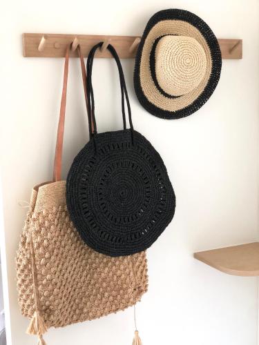 two bags and a hat hanging on a wall at JACARANDA II Appartement in Mandelieu-la-Napoule
