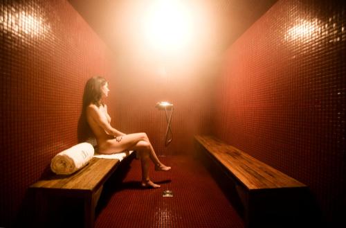 a woman sitting on a bench in a room with a light at Hôtel Ville d'Hiver in Arcachon