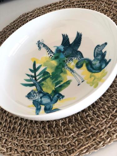 a plate with birds on it sitting on a table at JACARANDA II Appartement in Mandelieu-la-Napoule