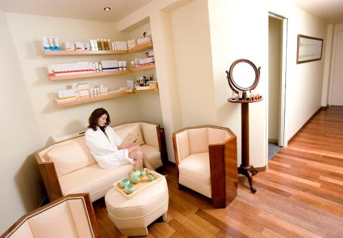 a woman sitting in a chair in a salon at Hôtel Ville d'Hiver in Arcachon