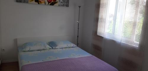 a small bed in a room with a window at Apartment Rita in Makarska
