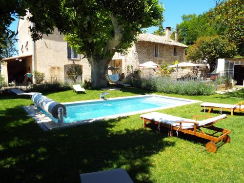 a backyard with a swimming pool with a tree at La Maison du Moulin de Tartay in Avignon