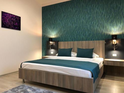 a bedroom with a large bed with blue sheets at Pensiunea Lido in Piatra Neamţ