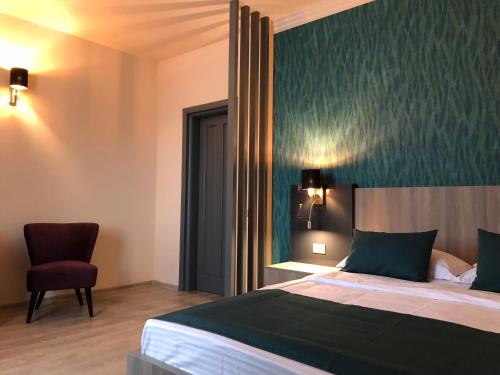 a hotel room with a bed and a chair at Pensiunea Lido in Piatra Neamţ