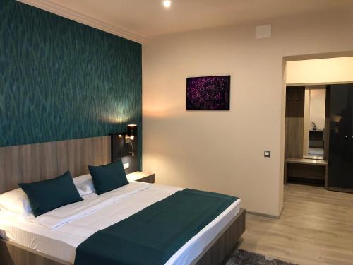 a bedroom with a large bed with blue pillows at Pensiunea Lido in Piatra Neamţ