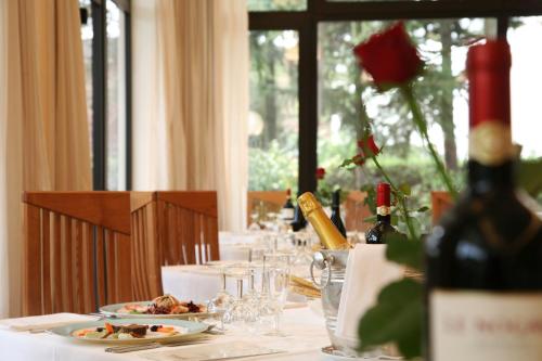 a table with plates of food and a bottle of wine at Hotel Terme Marconi in Montegrotto Terme