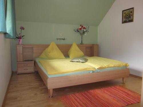 a bedroom with a bed with yellow sheets and yellow pillows at Ferienhaus Pirker in Eisentratten