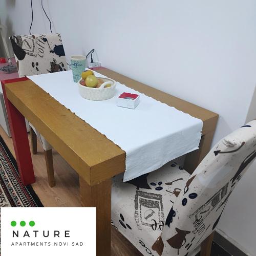 a table and a chair with a bowl of fruit on it at Just nature in Novi Sad