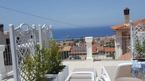 a balcony with white chairs and a view of the city at Appartamenti Borgo Panoramico N 5 in Tropea