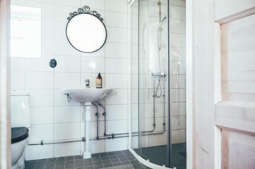 uma casa de banho com um chuveiro, um lavatório e um espelho. em Farmors Lada em Glommen
