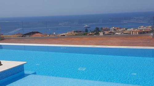 a blue swimming pool with a view of a city at Appartamenti Borgo Panoramico n.1 in Tropea